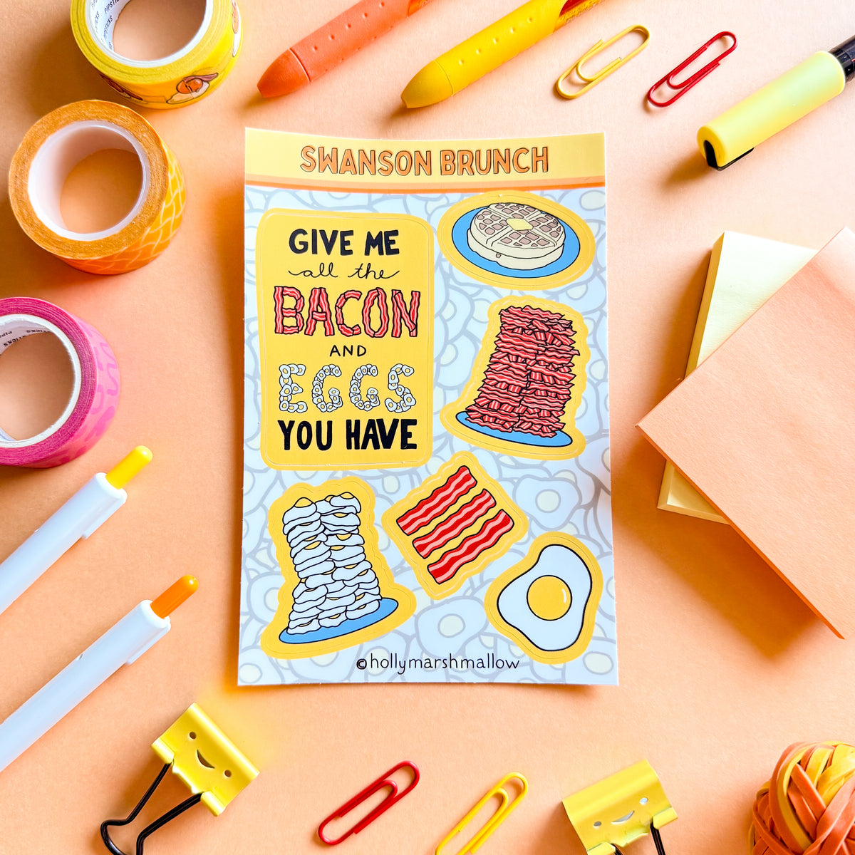 Sticker Sheet with hand lettered 'Give me all the Bacon and Eggs you have' sticker and illustrated breakfast stickers on a colorful background with stationery items.