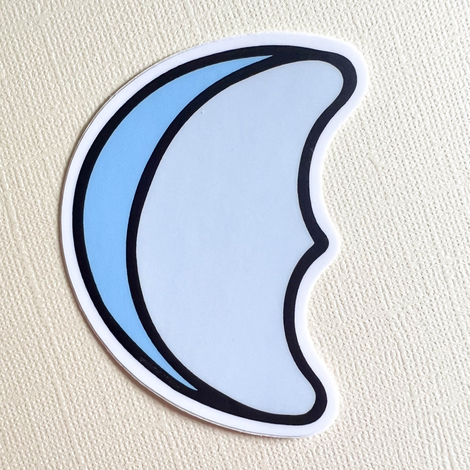 Sticker with a blue and white crescent moon design on a yellow background