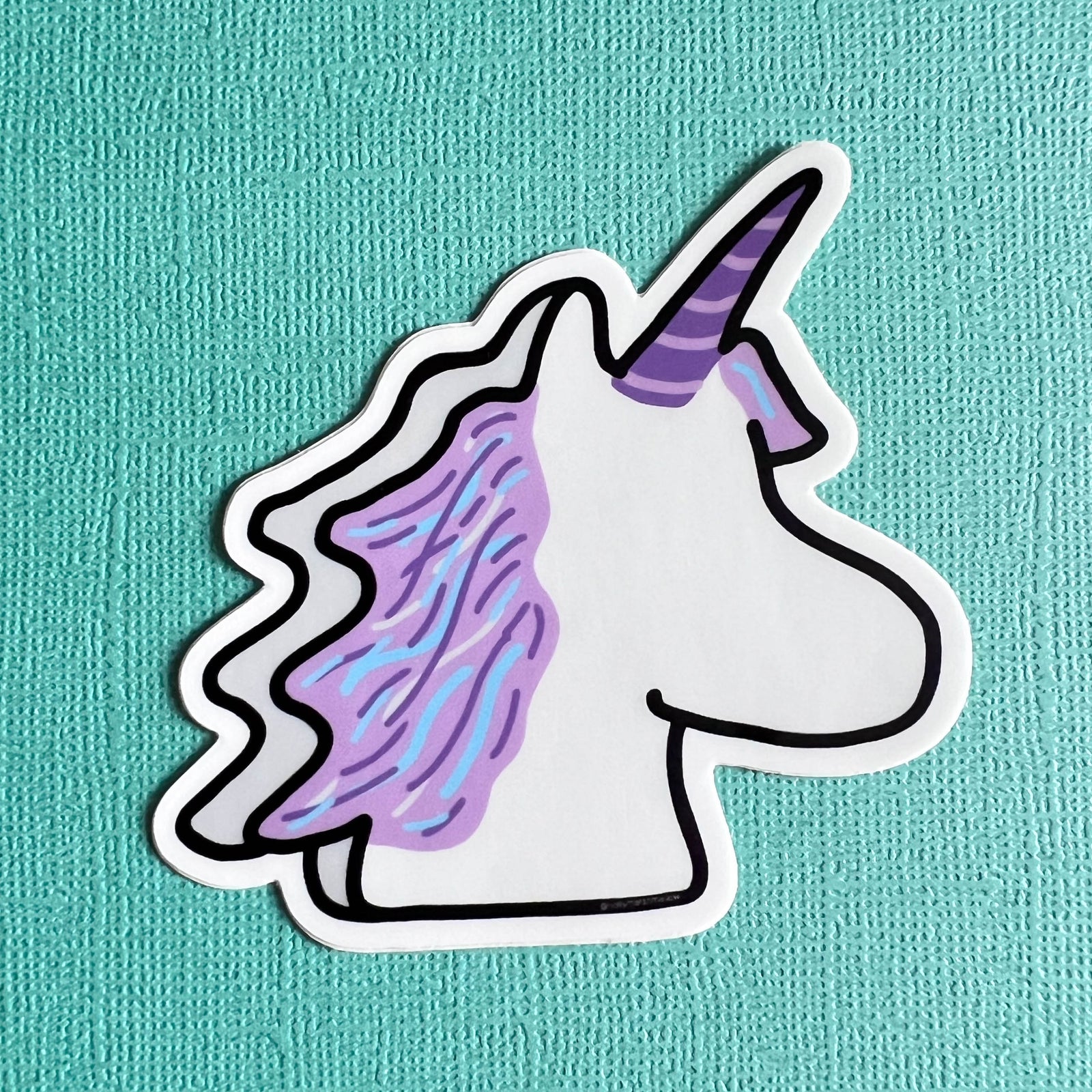 Marshmallow Unicorn sticker with a purple mane on a teal background