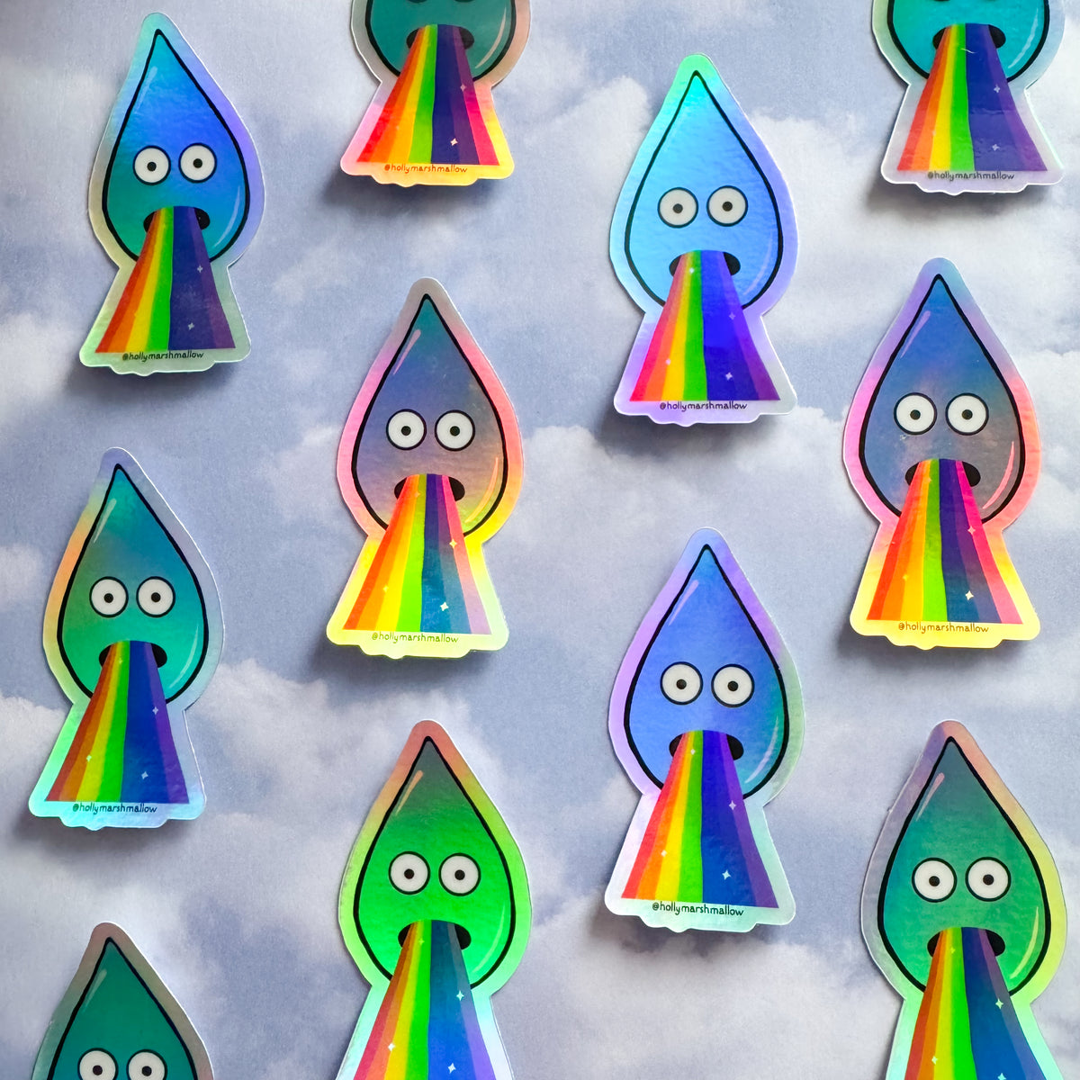 Stickers of barfing raindrop holographic stickers with rainbow barf on a cloud background