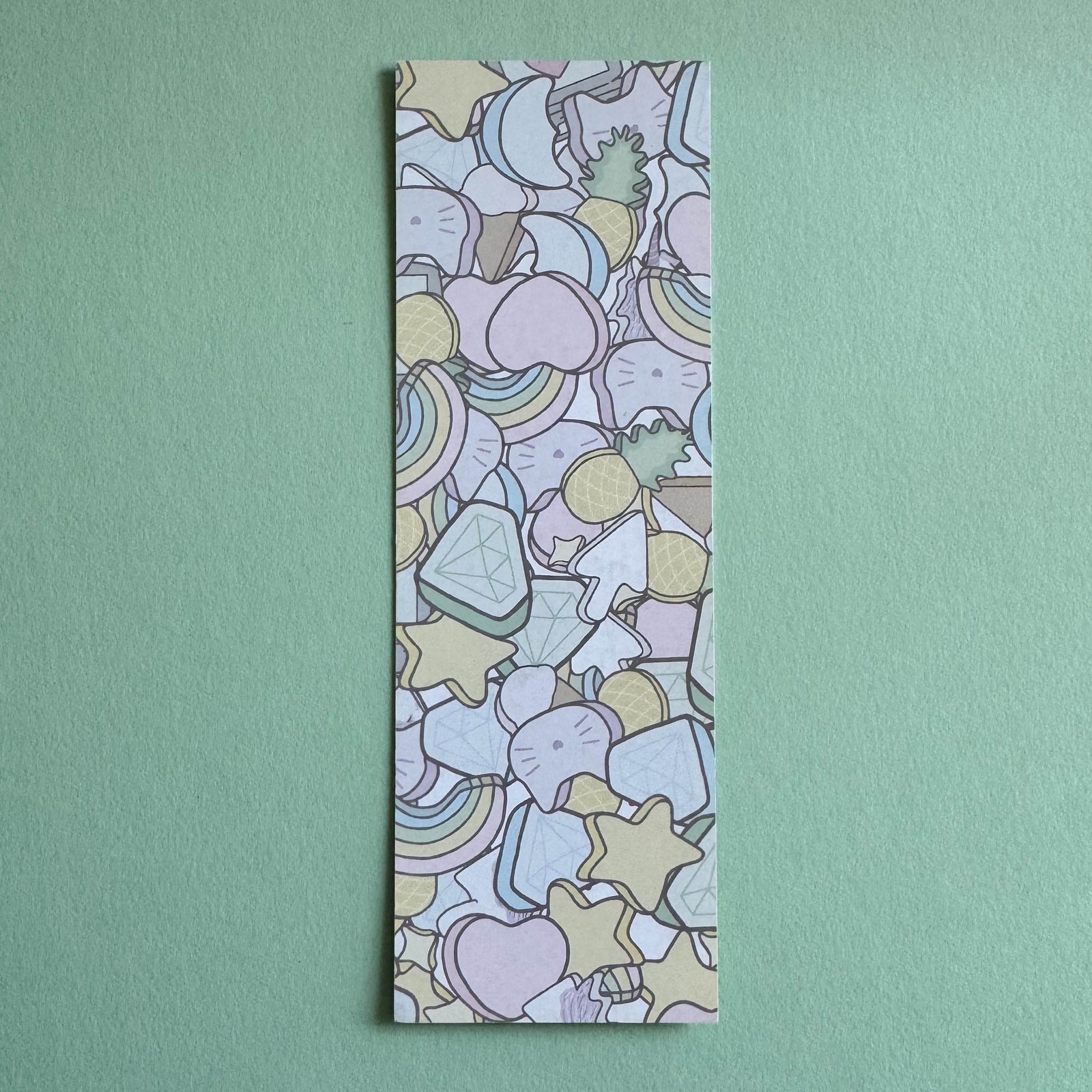 Paper bookmark with scattered marshmallow pattern illustration on a seafoam background