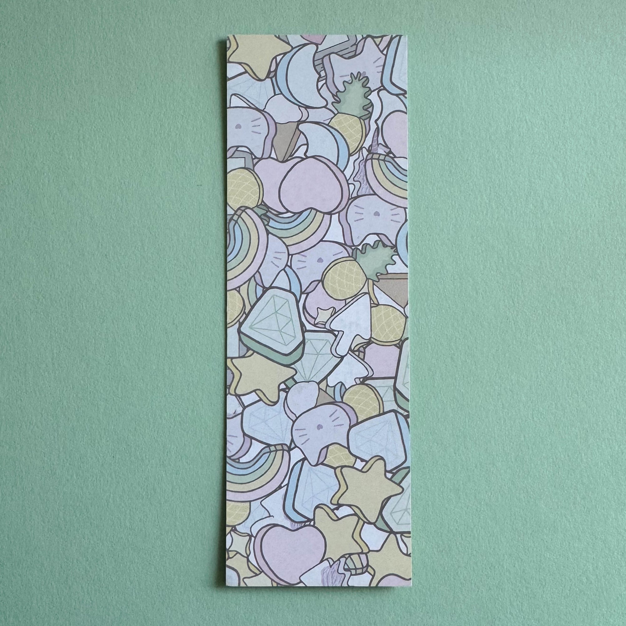 Paper bookmark with scattered marshmallow pattern illustration on a seafoam background