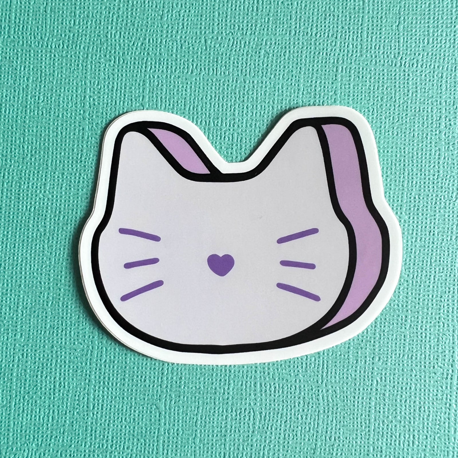 Sticker of a purple marshmallow cat on a teal background