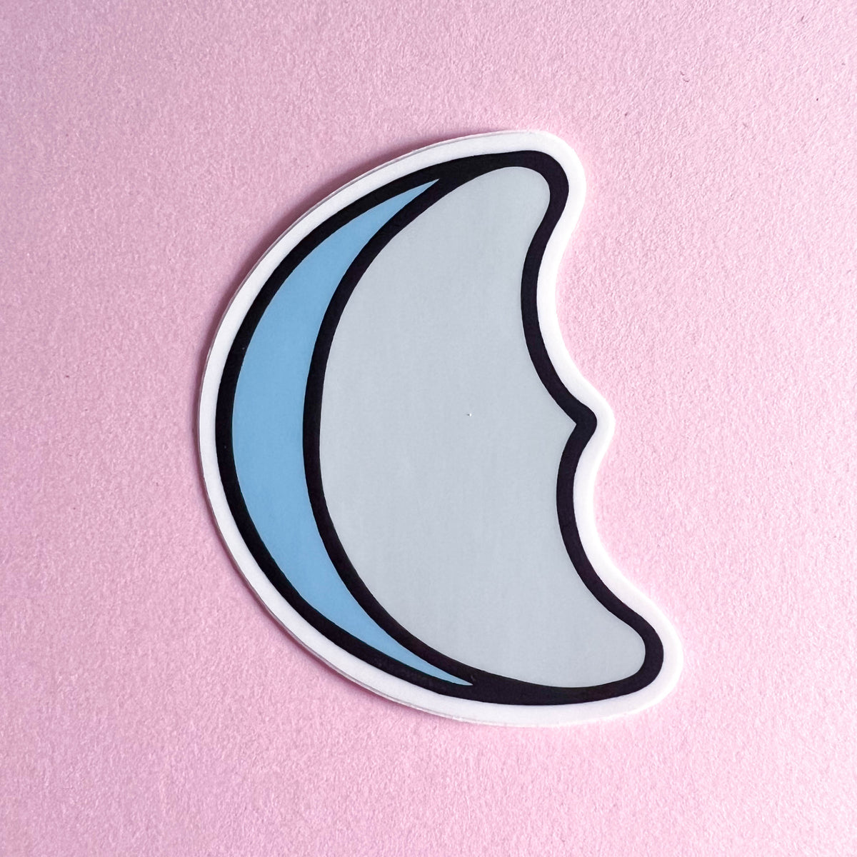 Half moon-shaped sticker on a pink background