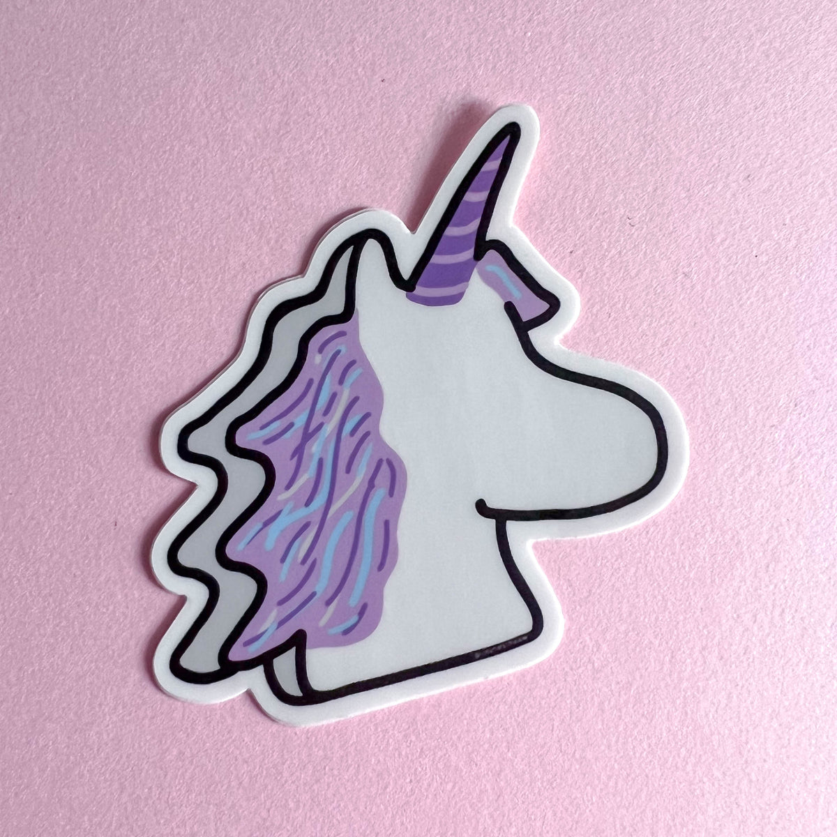 Marshmallow Unicorn sticker with a purple horn on a pink background