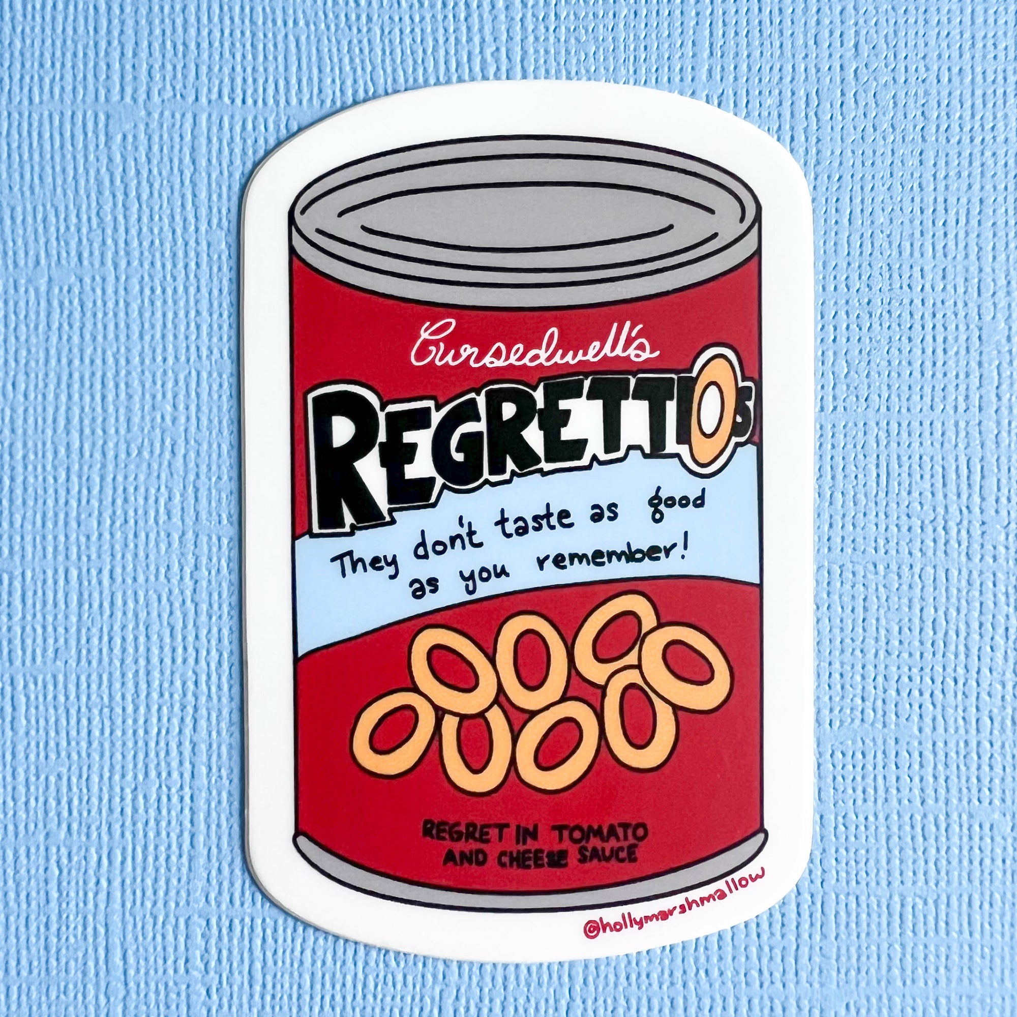 Sticker of a can labeled 'Cursedwell's Regretti-os' on a blue background