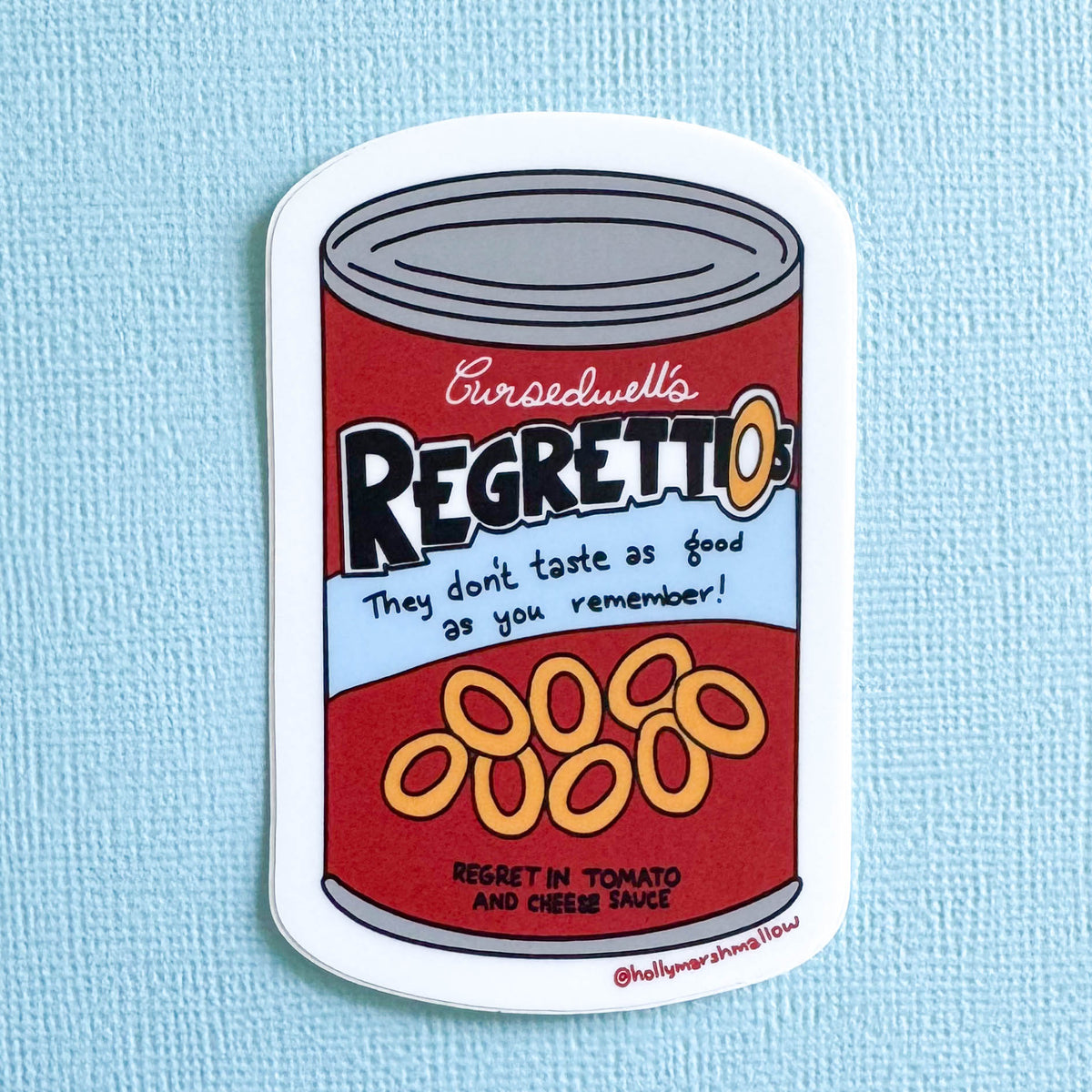 Sticker of a can labeled 'Cursedwell's Regrettios' on a light blue background