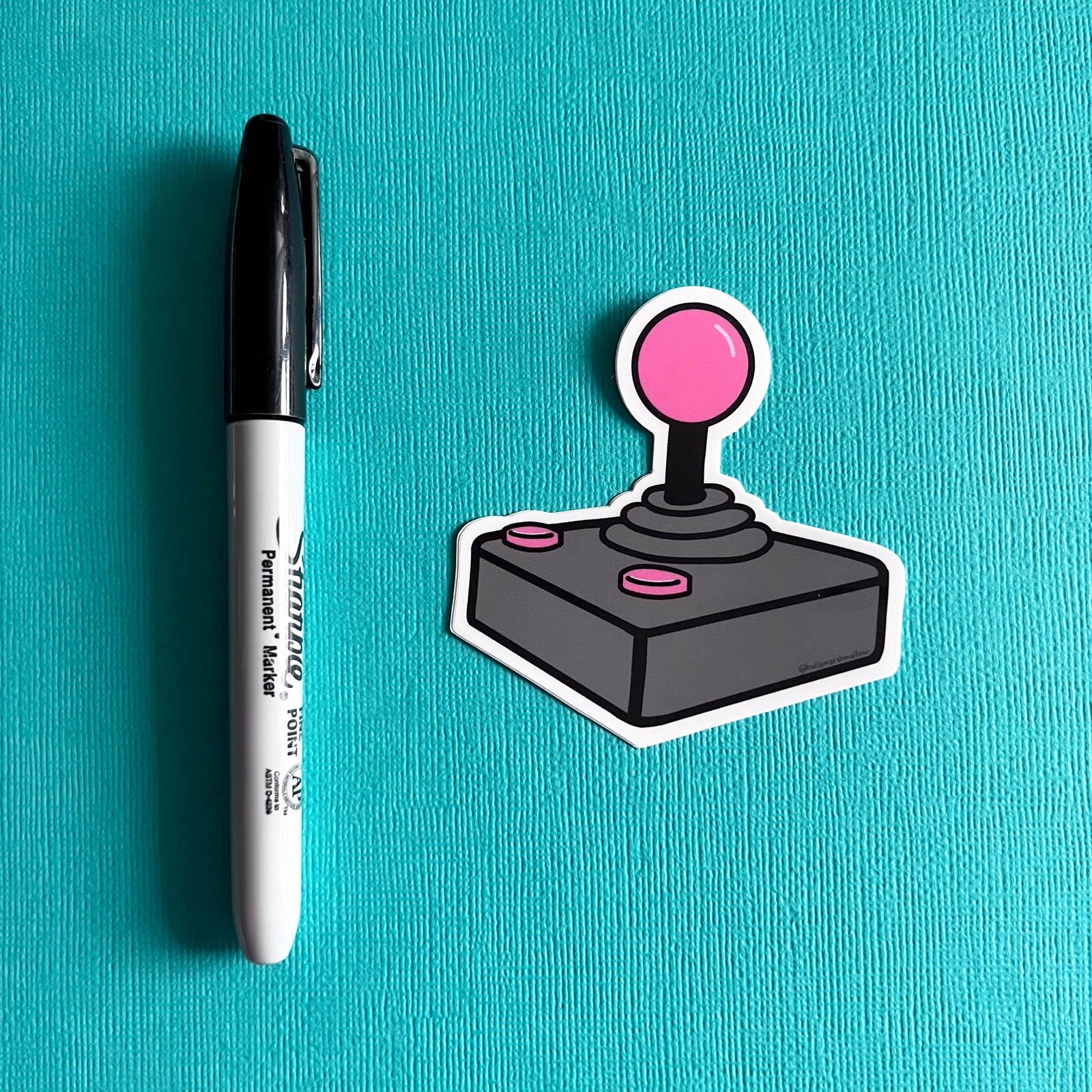 Joystick sticker next to a marker on a blue background