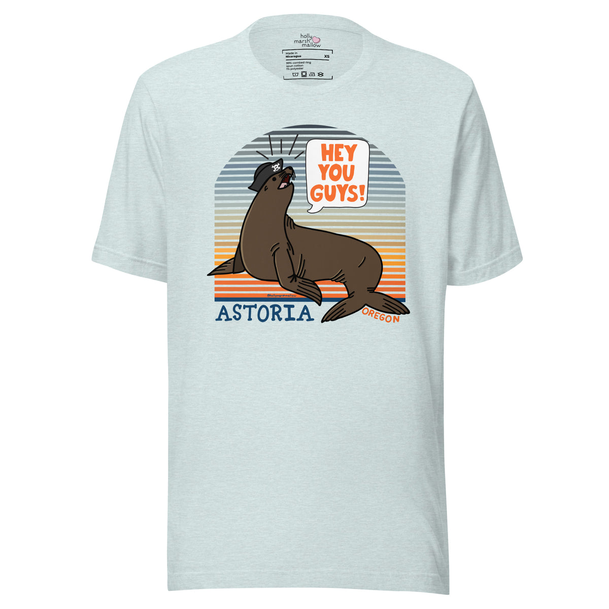 An ice blue t-shirt of a sea lion in a tricorn hat yelling HEY YOU GUYS with a sunset stripe background and hand-lettered Astoria, Oregon on the bottom on a white backround