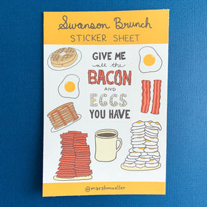 Swanson Brunch Sticker Sheet on a navy background. Sticker sheet has kiss cut stickers of breakfast food and a hand-lettered sticker that says "Give me all the bacon and eggs you have"