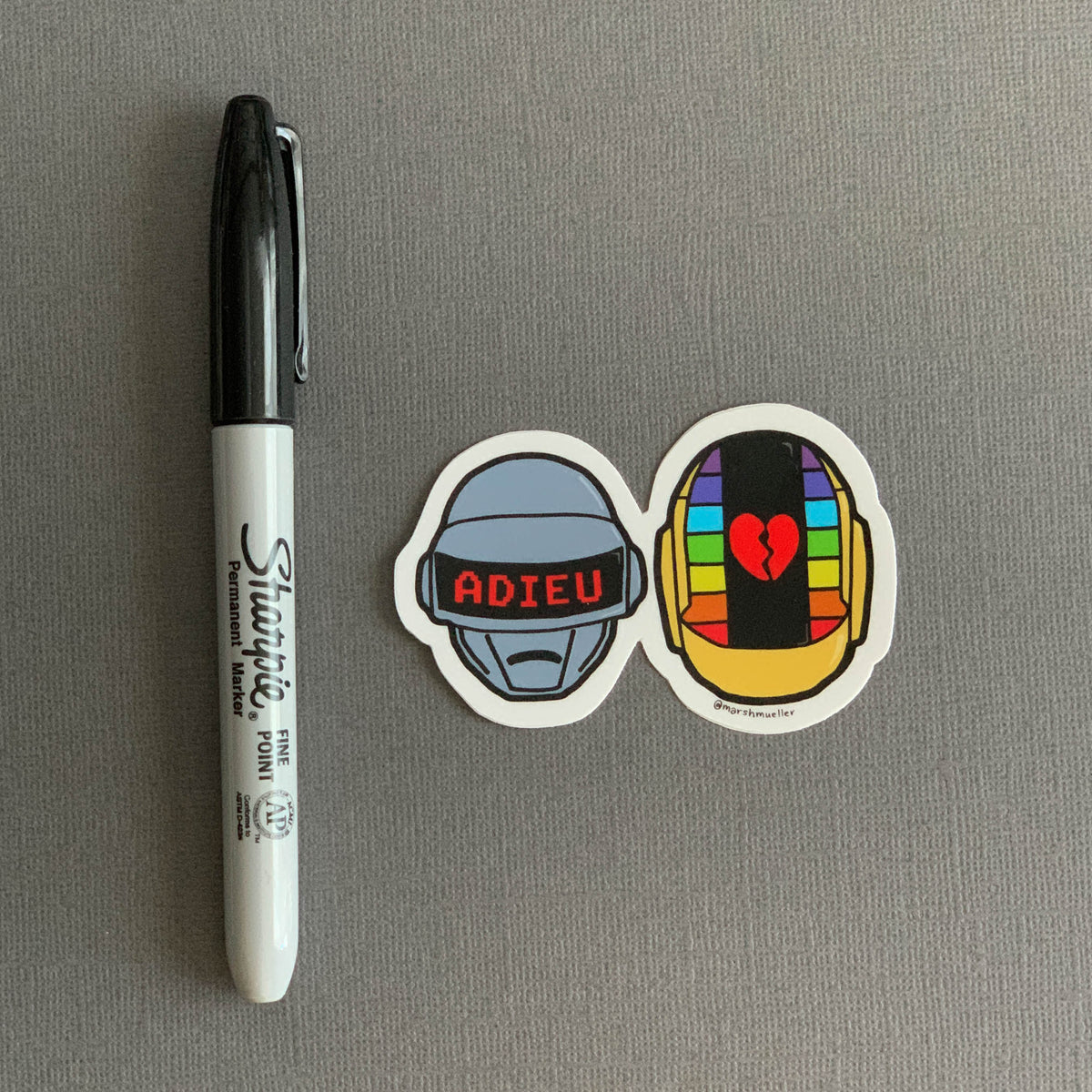 Daft Punk Die Cut Sticker next to a black Sharpie for scale on a grey background