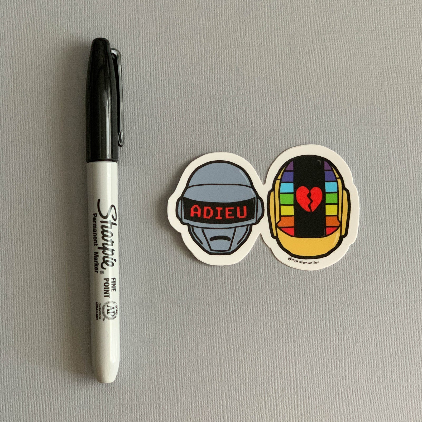 Daft Punk Die Cut Sticker by Marshmueller next to a black Sharpie for scale on a grey background
