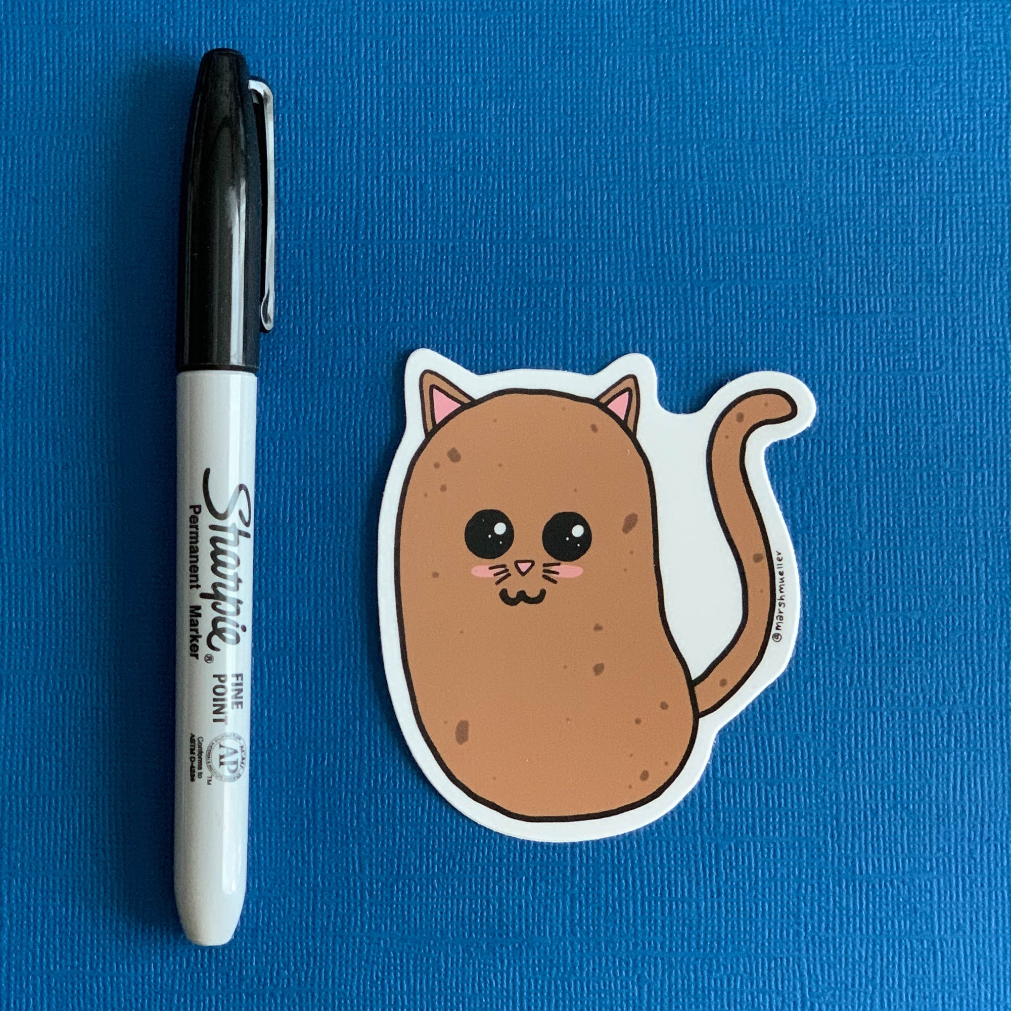 Potato Cat Die Cut sticker on a navy background next to a black Sharpie for scale