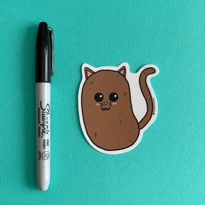 Potato Cat Die Cut sticker by Marshmueller on a teal background next to a black Sharpie for scale